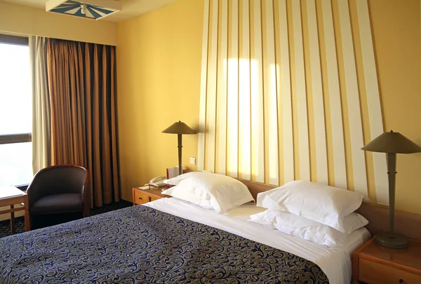 Hotel room with yellow walls and  curtains