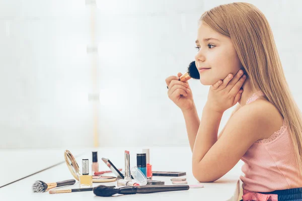 Little girl applying make-up