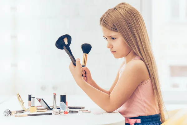 Girl choosing  make-up brushes