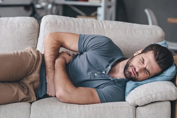 Young man hugging his belly