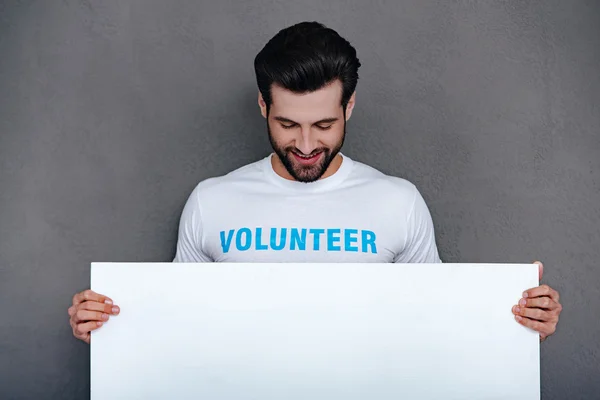 Man in volunteer t-shirt holding  board