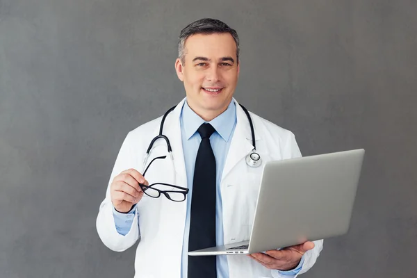 Mature male doctor with laptop