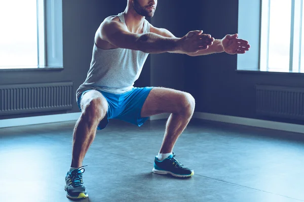 Young man doing  squat