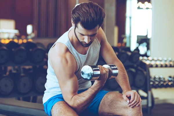 Handsome man with dumbbell at gym