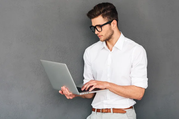 Man holding laptop and typing