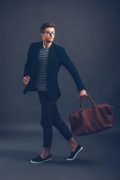 Man in glasses carrying bag