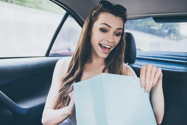 Woman looking inside of the shopping bag