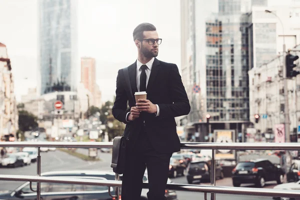 Man in full suit holding coffee cup