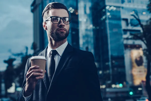 Man in full suit holding coffee cup