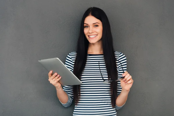 Smiling woman holding digital tablet