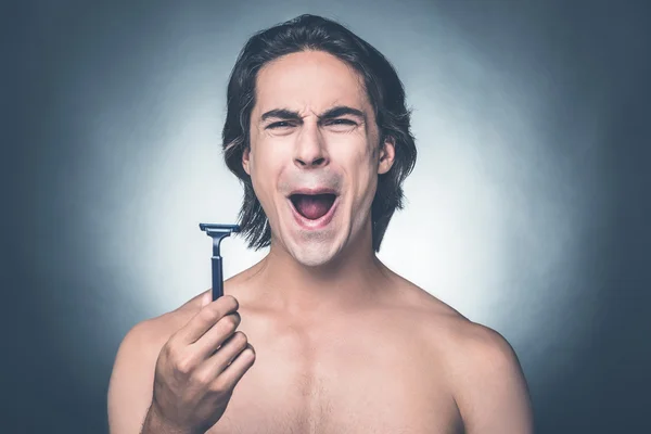 Shirtless man holding razor