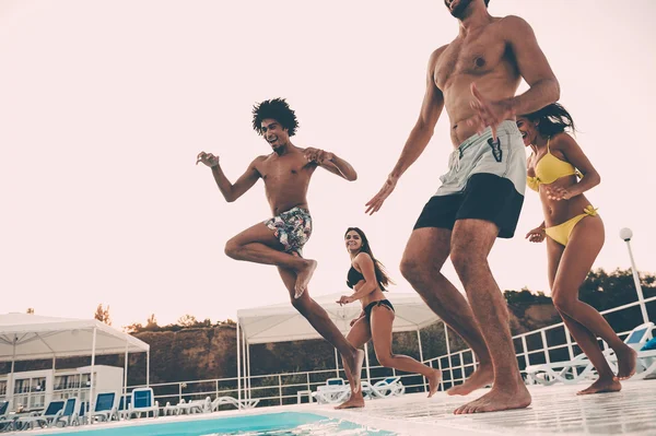 Best friends jumping into swimming pool