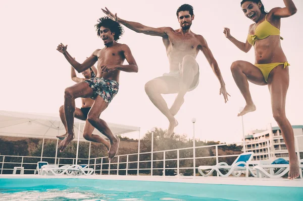 Best friends jumping into swimming pool