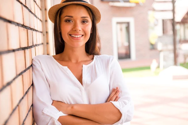 Woman in hat keeping arms crossed