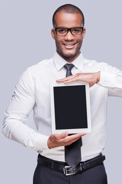 African man in shirt and tie showing digital tablet