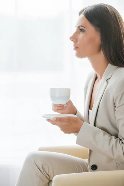 Businesswoman in suit drinking coffee