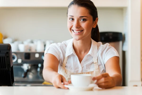 Woman in apron serving coffee