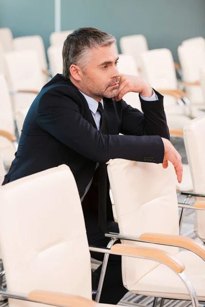 Bored mature man in empty conference hall