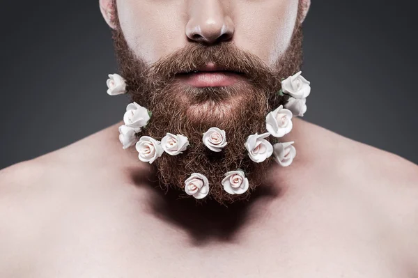Shirtless man with flowers in his beard