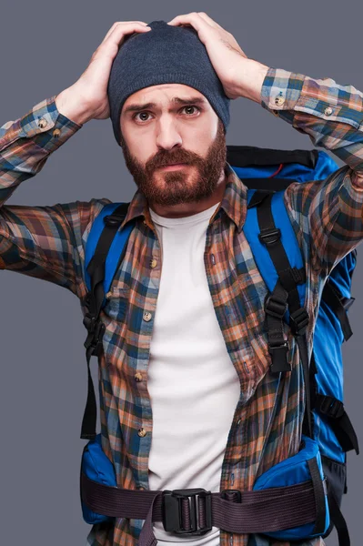 Frustrated young bearded man carrying backpack