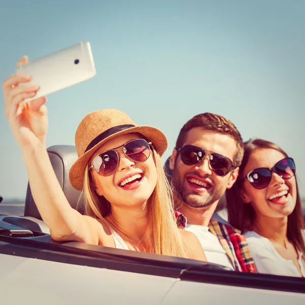 People in convertible and making selfie
