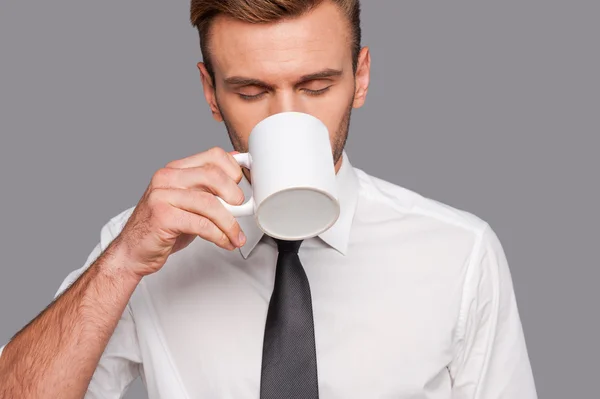 Man in formalwear holding coffee cup
