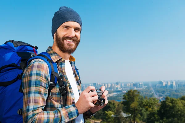 Man carrying backpack and holding camera
