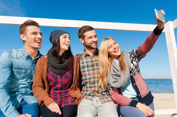 Four happy young people making selfie