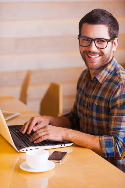 Man working on laptop and smiling