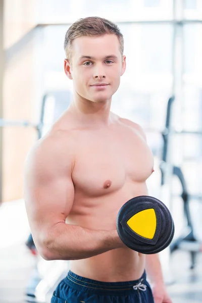 Muscular man training with dumbbells