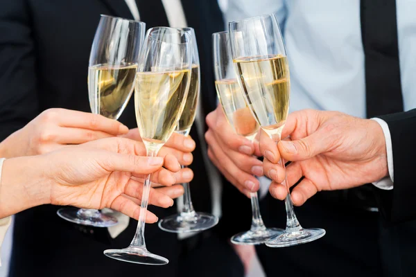 Business people holding flutes with champagne