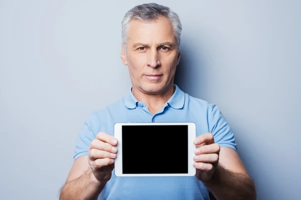 Senior man showing digital tablet