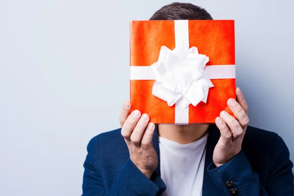 Man covering his face by gift