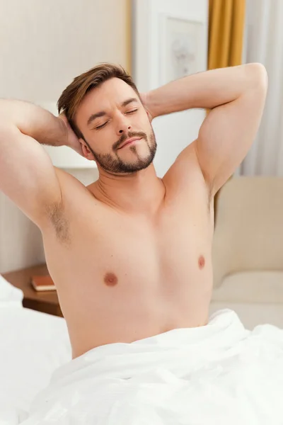 Man stretching out in bed