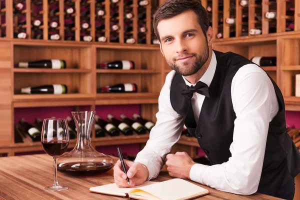 Sommelier writing in note pad