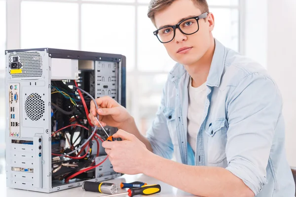 Young man repairing computer