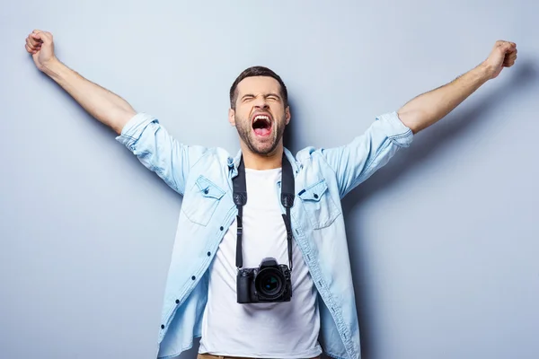 Happy young man with digital camera