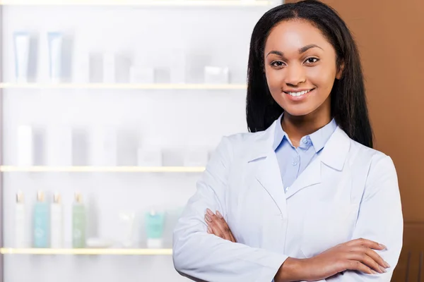 Woman in lab coat in drugstore