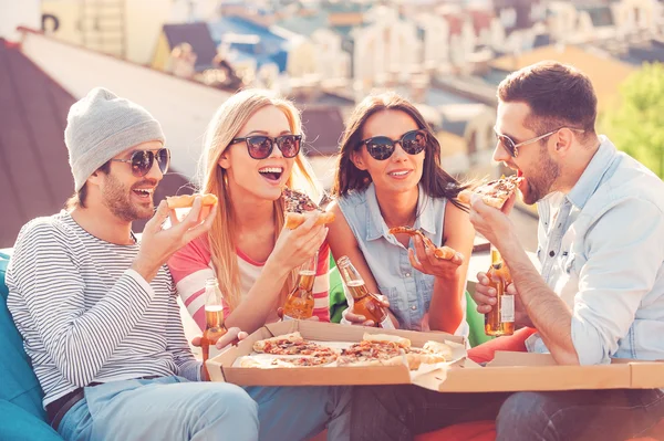 People eating pizza and drinking beer