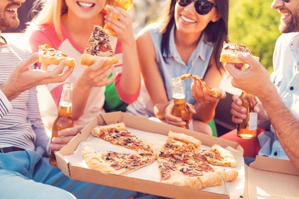 People eating pizza and drinking beer