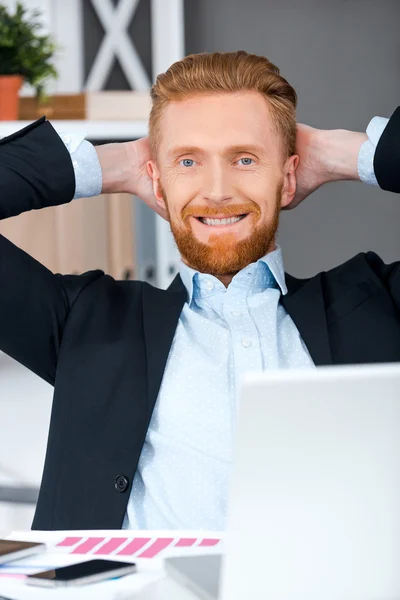 Bearded businessman holding head in hands