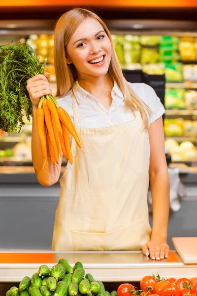 Female seller smiling carrots