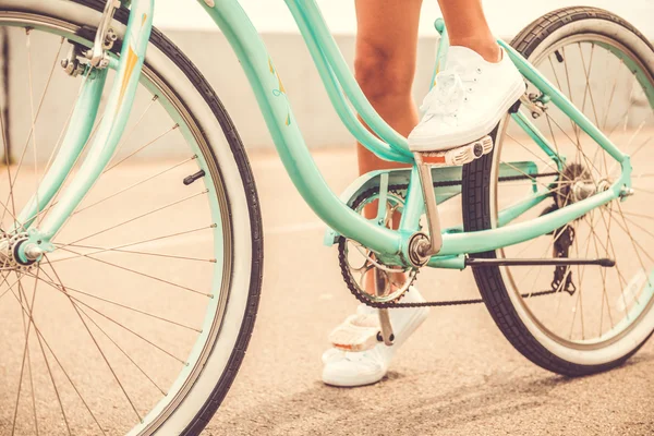 Woman holding her foot on bicycle pedal