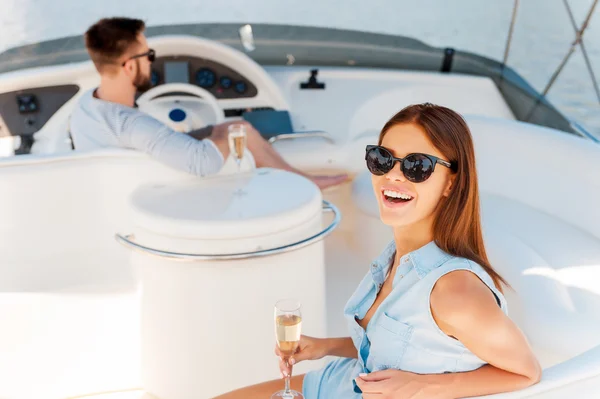 Woman holding glass with champagne on yacht