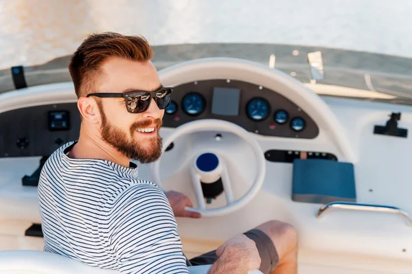 Young man driving yacht
