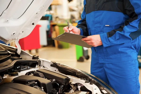 Man in uniform examining car