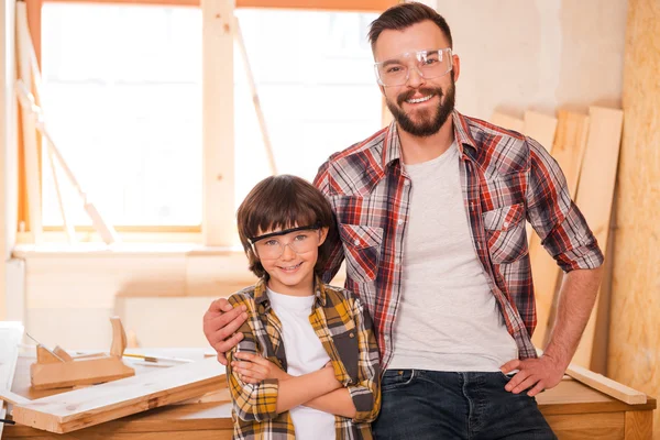 Carpenter embracing his son in workshop