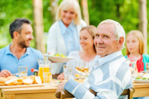 Family sitting at dining table outdoors