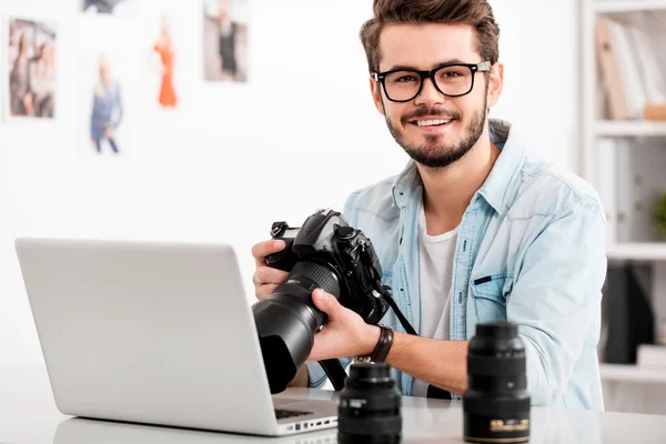 Happy young man holding camera