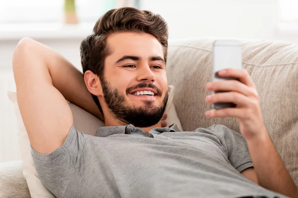 Smiling bearded man holding mobile phone